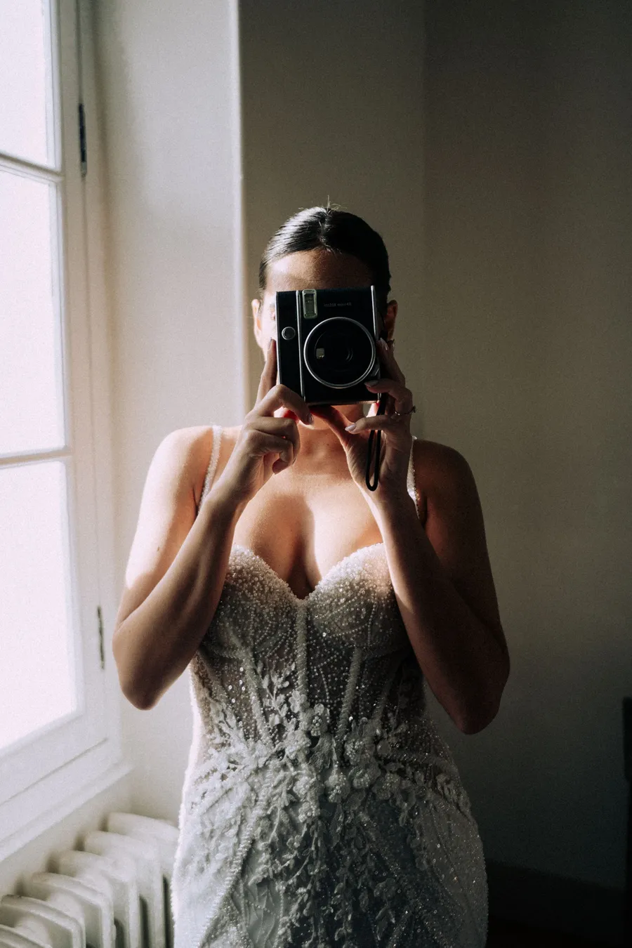 Portrait de Caroline dans sa robe de mariée face au miroir