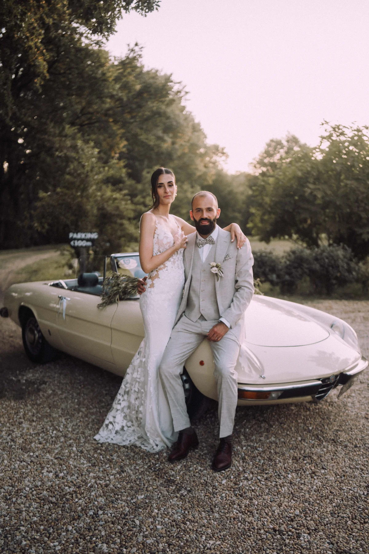 Couple de mariés près d’une voiture dans un décor provençal