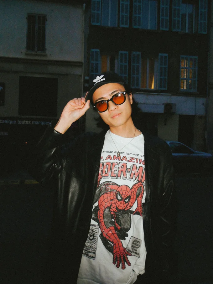 Steve Kongphengta avec lunettes, veste noire et t-shirt Spider-Man